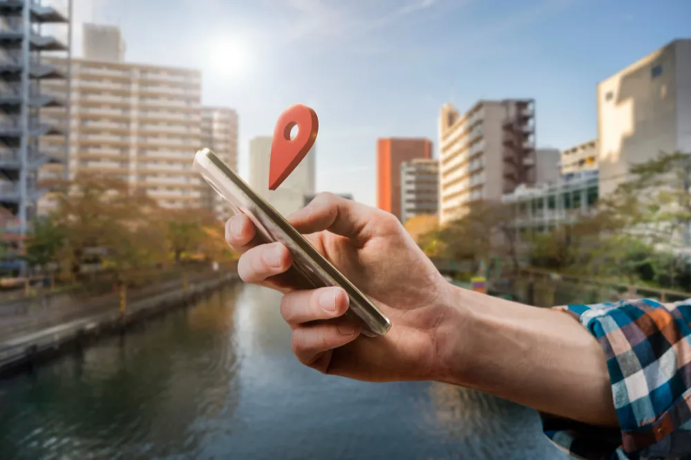 Căutare locală pe telefon cu pin de localizare într-un oraș