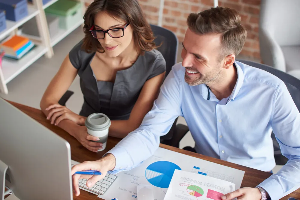 Doi specialiști analizează prețurile serviciilor SEO dintr-o ofertă