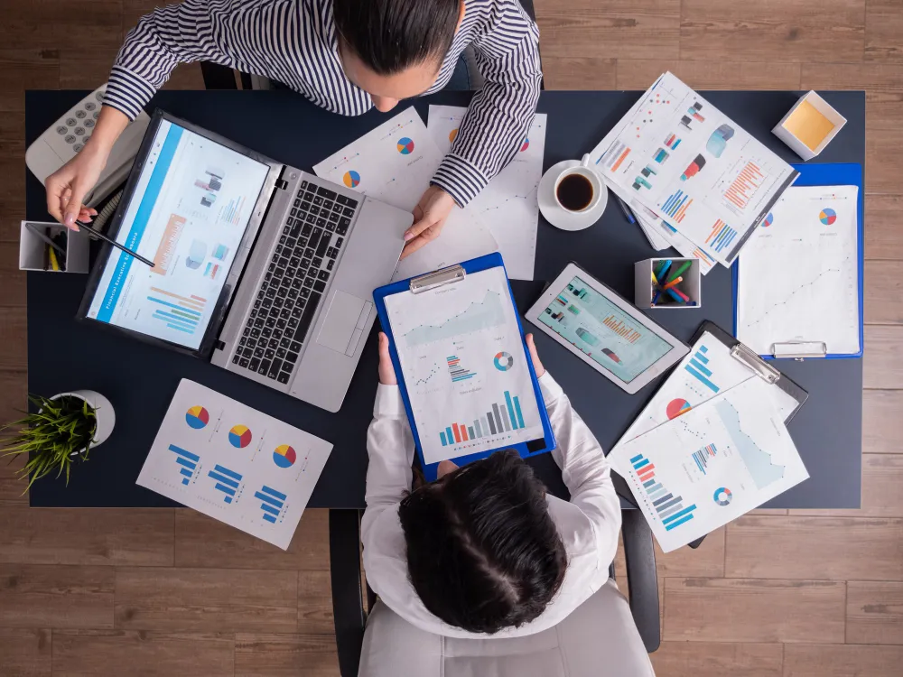 Echipă care analizează rapoarte și grafice de performanță pentru servicii de marketing